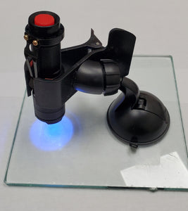 UV curing flashlight and suction cup holder on glass pane